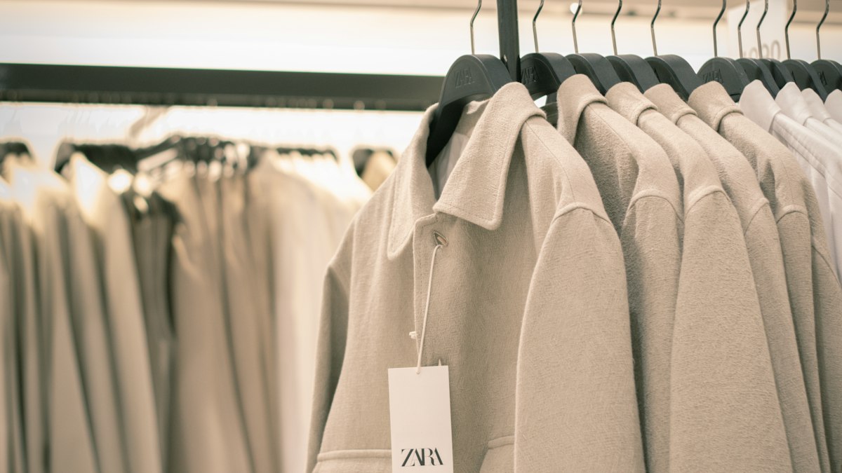 A tag hangs among garments on a clothing rack.
