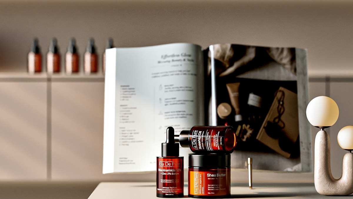 Cosmetic bottles stand beside an open book on a counter.